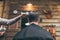 Male barber combing hair of customer in barber