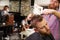 Male Barber Giving Client Haircut In Shop