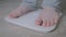 Male bare feet stepping on digital floor scales - man weighing himself: close up