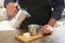 Male Barista preparing fresh espresso in coffee maker for customer in a fancy coffee shop. Cafe owner serving a client at the