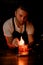 male bartender carefully lights a fire over a glass with a drink and ice