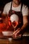 Male bartender hand holds wineglass with beverage decorated with hearts and with smoky air bubble