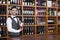 Male Bartender Holding Red Wine Bottle In Shop