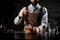 Male bartender stirring a brown cocktail with ice cubes in the glass with special spoon