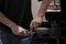 Male bartender on the workplace. Closeup image of male hands while making coffee using coffeegrinder and coffeemachine