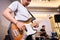 a male bassist plays an electric bass guitar during rehearsal with his band