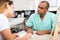 Male beautician filling medical card with woman client