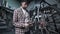 A male bicycle mechanic aligns the tension spokes of a bicycle wheel with a special tool at the workplace in the