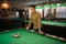 Male billiard player, poolroom on background