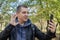 A male blogger in a leather jacket in the forest conducts a video conference for his audience. The concept of online learning,