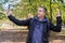 A male blogger in a leather jacket in the forest conducts a video conference for his audience. The concept of online learning,