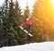 Male boarder jumping and keeps one hand on the snowboard