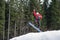 Male boarder on the snowboard jumping over the slope