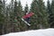 Male boarder on the snowboard jumping over the slope