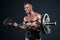 Male bodybuilder emotionally shakes his biceps with a barbell