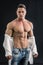 Male bodybuilder opening his shirt revealing muscular torso
