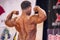 Male bodybuilder shows his best back double biceps pose