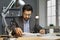 Male bookkeeper sitting at an office desk, doing paperwork, and reading documents