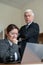 The male boss indicates the female subordinate a mistake. A gray-haired mature business man scolds an employee for