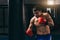 Male boxer in red gloves doing cardio boxing workout with punching bag