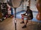 Male Boxer Training In Gym Sitting On Stool Putting Wraps On Hands Standing Next To Punching Bag