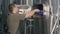 A male brewer pulls out spent malt from a beer tank for brewing beer. Beer production