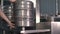 A male brewer washes and sterilizes beer kegs using an automatic beer keg sterilization machine. Close-up