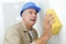 Male builder cleaning wall with sponge