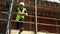Male builder foreman construction worker on building site standing on scaffolding