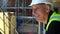 Male builder foreman construction worker on building site talking with colleagues