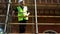 Male builder foreman, worker, surveyor or architect working on construction building site standing on scaffolding