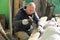 A male builder hammering nails into the board.