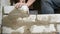Male builder laying white brick on cement and standing wall. Hands of man laying building bricks close up view