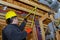 Male builder measuring plastic pipes with new home construction in hot and cold blue and red pex pipe layout in pipes and exposed