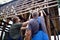 Male building workers discussing building plans over unfinished wooden house