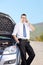 Male businessperson talking on phone on an open road