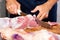Male Butcher Cutting Raw Meat With Knife