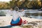 Male camper stretching in sleeping bag on wild beach.