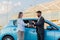 The male car salesman hands over the keys to the female buyer, the purchase agreement is successfully completed