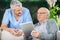 Male Caretaker Looking At Senior Man Using Tablet