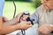Male Caretaker Measuring Blood Pressure Of Elderly