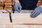 Male carpenter hands using wood glue and timber on a wooden table for handmade furniture. Close up. Hobby for man