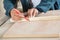 Male Carpenter Marking On Wood With Pencil