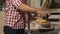 Male carpenter polishing piece of wood at his workshop