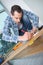 Male carpenter uses measuring tape measure wood