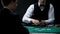 Male casino croupier dealing cards for businessman, chance to win at poker game
