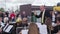 Male caucasian conductor leads a seated brass band in outdoor location