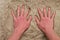 Male Caucasian hand in the salt sand on the beach.