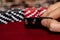 A male caucasian hand Showing a Pair of Aces in the hole, Hearts and Diamonds, on a unique deck of black faced cards with Red and