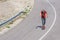 Male caucasian longboarder riding downhill on an empty road, preparing for a speed tuck on the next turn he has to make. Wearing a